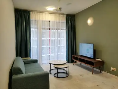 a living room with a couch and a table and a tv at City Tropical Home II in George Town
