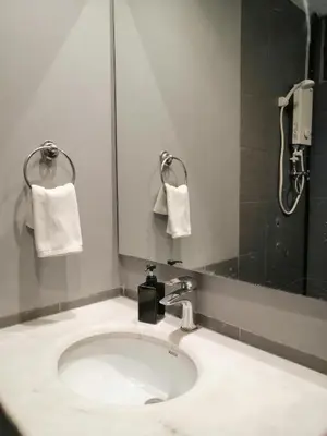 a bathroom with a sink and a shower and towels at City Tropical Home II in George Town
