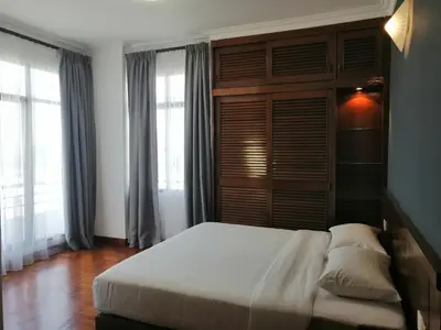 a bedroom with a large white bed and windows at City Tropical Home II in George Town