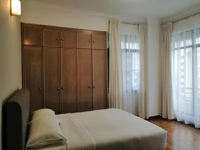 a bedroom with a bed and a wooden cabinet at City Tropical Home II in George Town
