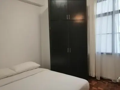 a bedroom with a bed and a black cabinet at City Tropical Home II in George Town
