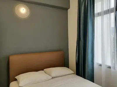 a bedroom with a bed and a window with a light at City Tropical Home II in George Town