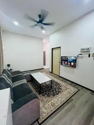 a living room with a couch and a tv at Inap Kasih Homestay Gua Musang Bandar Utama - Free Wifi, Netflix, Coway Provided in Gua Musang