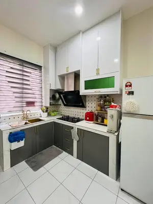 a kitchen with white cabinets and a refrigerator at Inap Kasih Homestay Gua Musang Bandar Utama - Free Wifi, Netflix, Coway Provided in Gua Musang