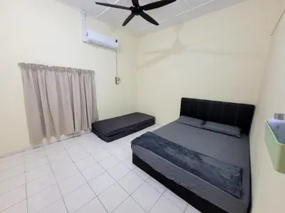 a bedroom with a bed and a ceiling fan at Pangkor Homestay in Pangkor