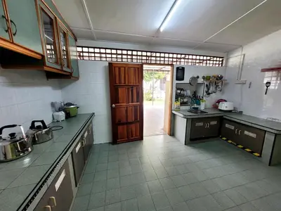 a large kitchen with a door open to a room at Pangkor Homestay in Pangkor