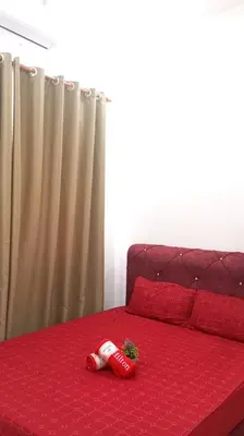 a coca cola bottle on a red bed at Affan Homestay in Seri Iskandar