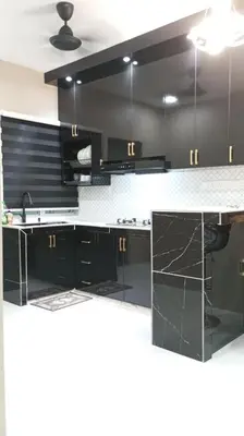 a black kitchen with black cabinets and a counter at Affan Homestay in Seri Iskandar