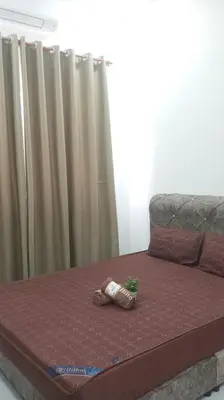 a bed with a pair of slippers on top of it at Affan Homestay in Seri Iskandar
