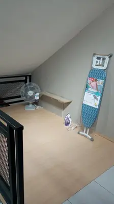 a room with a bed and a desk and a fan at Affan Homestay in Seri Iskandar