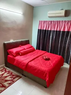 a bedroom with a bed with red sheets and a window at Airis Homestay Bertam Perdana in Kepala Batas