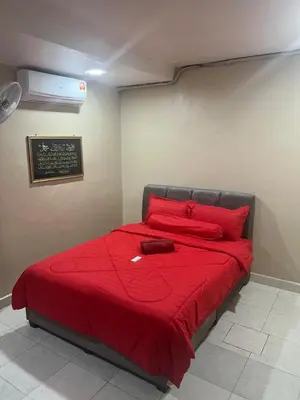 a bedroom with a bed with a red blanket at Airis Homestay Bertam Perdana in Kepala Batas