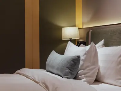 a bedroom with a bed with white pillows and a lamp at Break & Stay formerly known as BreakX Hotel in George Town