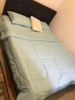 a bed with white sheets and a pillow on it at Opah Palas Homestay in Brinchang
