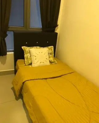 a bed with a yellow blanket and a window at Opah Palas Homestay in Brinchang
