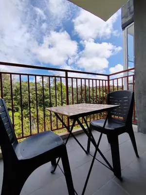 a table and two chairs on a balcony with a view at MujiStyle Brinchang Emerald Apartment Cameron 8guests 3bedrooms3bathroom in Brinchang