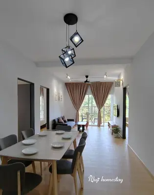 a dining room and living room with a table and chairs at MujiStyle Brinchang Emerald Apartment Cameron 8guests 3bedrooms3bathroom in Brinchang