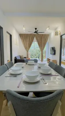 a table with bowls and plates on it in a living room at MujiStyle Brinchang Emerald Apartment Cameron 8guests 3bedrooms3bathroom in Brinchang