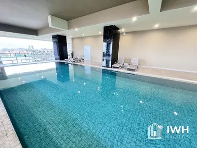 a large swimming pool in a hotel with blue water at ICC Ipoh Town Premium Suites By IWH Suites in Ipoh