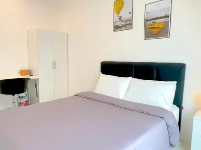 a bedroom with a white bed with a blue headboard at Anderson Ipoh Blissful Homestay in Ipoh