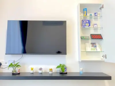 a shelf with potted plants and a tv on a wall at Anderson Ipoh Blissful Homestay in Ipoh