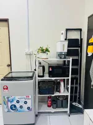 a kitchen with a small refrigerator and a shelf at Inap Kasih Homestay GM in Gua Musang