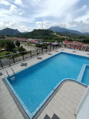 a swimming pool at a hotel with a mountain in the background at SS APARTMENT MUTIARa in Gua Musang