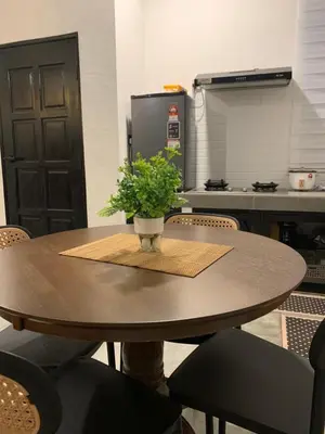 a table with a potted plant on it in a kitchen at RumaTisa in Teluk Intan