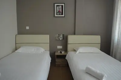 two beds sitting next to each other in a bedroom at Welcome Inn GM in Gua Musang