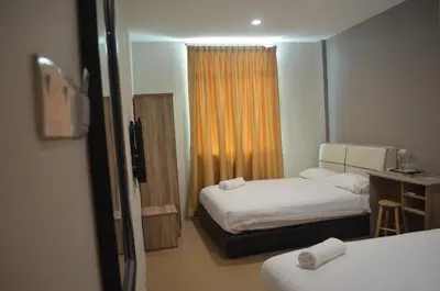 a hotel room with two beds and a window at Welcome Inn GM in Gua Musang