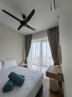a bedroom with a bed with a ceiling fan and a window at Macalister Suite - 2 Bedrooms in George Town
