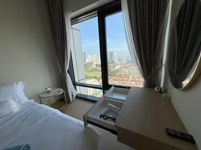 a hotel room with a bed and a large window at Macalister Suite - 2 bedrooms in Kampong Makam