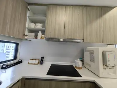 a kitchen with a microwave and a counter top with a microwave at Macalister Suite - 2 bedrooms in Kampong Makam