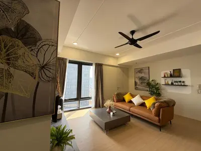 a living room with a couch and a ceiling fan at Macalister Suite - 2 bedrooms in Kampong Makam