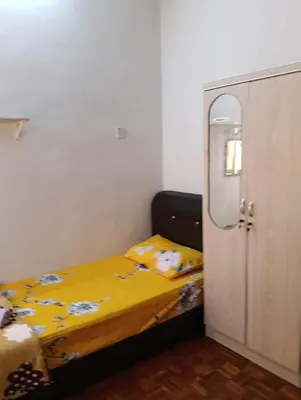 a small bedroom with a bed with a yellow blanket at Homestay Jannati Bandar Baru Putra Ipoh in Ipoh