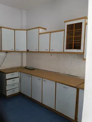 an empty kitchen with white cabinets and a window at Homestay Jannati Bandar Baru Putra Ipoh in Ipoh
