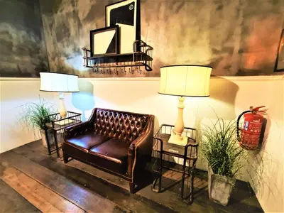a living room with a leather couch and two lamps at M Boutique Hotel Station 18 - Ipoh in Ipoh