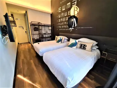 two beds in a room with white sheets at M Boutique Hotel Station 18 - Ipoh in Ipoh
