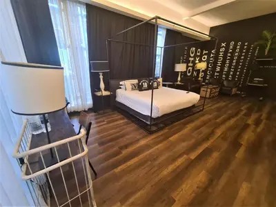 a bedroom with a canopy bed and wooden floors at M Boutique Hotel Station 18 - Ipoh in Ipoh