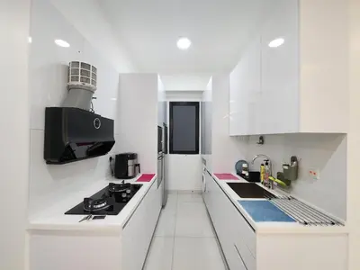 a white kitchen with a stove and a sink at Georgetown Modern CosyStay in George Town