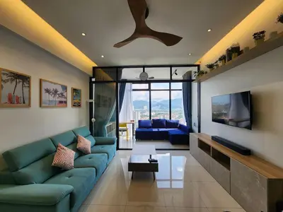 a living room with a blue couch and a tv at Georgetown Modern CosyStay in George Town