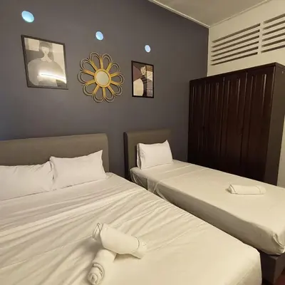two beds sitting next to each other in a room at TG103a Pet Friendly 15pax, near beach side in Tanjung Bungah