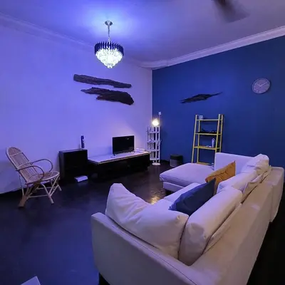 a living room with a white couch and a blue wall at TG103a Pet Friendly 15pax, near beach side in Tanjung Bungah