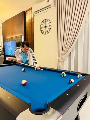 a man playing pool in a hotel room at MSprivate Pool-Ipoh Perak in Ipoh