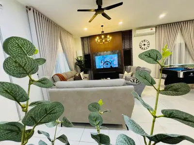 a living room with couches and a tv and plants at MSprivate Pool-Ipoh Perak in Ipoh