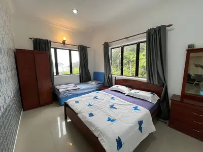 a bedroom with two beds and a mirror at Cottage Hill -Cameron Highlands in Cameron Highlands