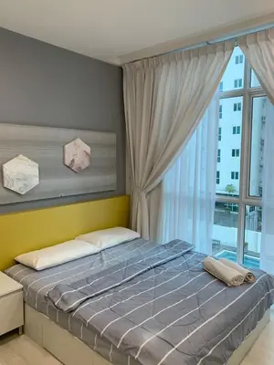 a bedroom with a large bed with a window at Straits Garden Suites in Jelutong