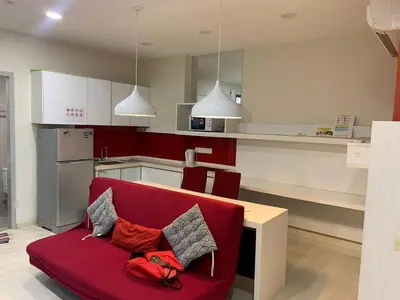 a living room with a red couch in a kitchen at Straits Garden Suites in Jelutong