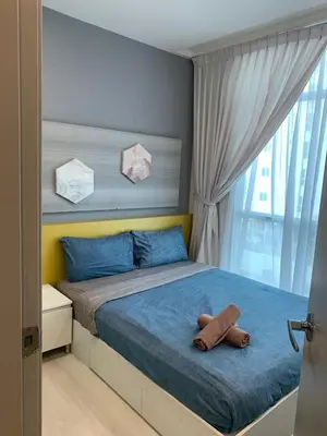 a bedroom with a bed with blue sheets and a window at Straits Garden Suites in Jelutong