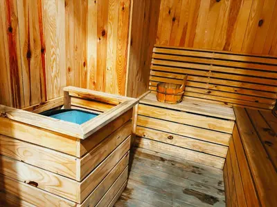 a wooden sauna with a wooden bucket in it at Big screen cinema tv, 5 queen bed Luxury apt 2cp in Jelutong